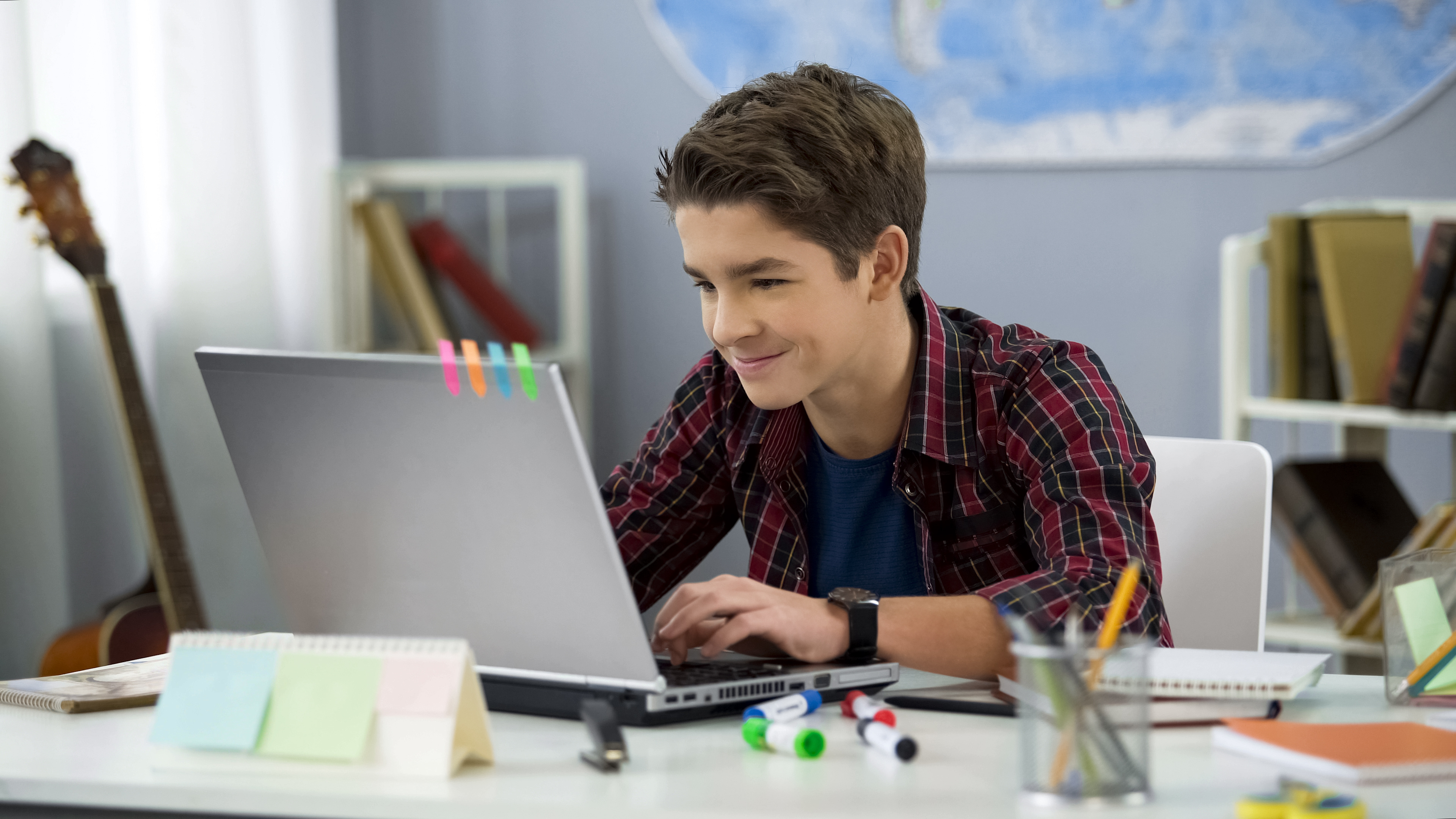 young boy learning in front of laptop smiling